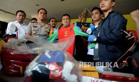 Petugas kepolisian menujukan barang bukti berserta tersangka hasil pengerebekan dugaan prostitusi gay bertajuk 