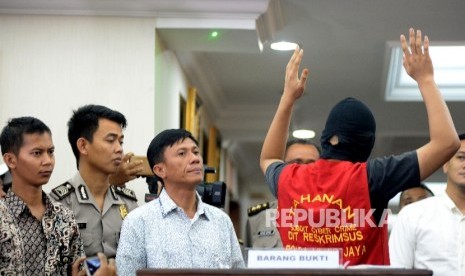 Petugas kepolisian menunjukan barang bukti dan tersangka saat rilis kasus tindak pidana pornografi melalui Facebook di Mapolda, Jakarta, Selasa (14/3).