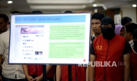 Petugas kepolisian menunjukan barang bukti dan tersangka saat rilis kasus tindak pidana pornografi melalui Facebook di Mapolda, Jakarta, Selasa (14/3).