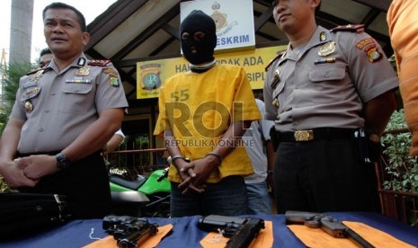  Petugas kepolisian menunjukkan barang bukti dan tersangka pada rilis tindak pidana menyimpan dan kepemilikan senjata api rakitan dan air softgun di Polsek Penjaringan, Jakarta Utara, Senin (26/8). ( Republika/Yasin Habibi)