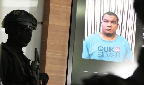 Police officer shows photograph of suspected terrorist during press conference in Jakarta, Thursday (June 22). 