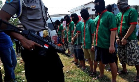 Petugas kepolisian menunjukkan tersangka dan barang bukti narkoba saat pemusnahan barang bukti narkoba di lapangan Polsek Palmerah, Jakarta Barat, Jumat (13/9).    (Republika/Prayogi)