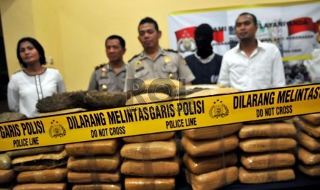   Petugas kepolisian sektor Cilandak menunjukan barang bukti dan tersangka pada rilis tindak pidana menjual dan mengedarkan narkotika jenis Ganja di Polsek Cilandak, Jakarta Selatan, Senin (10/6).  (Republika/Prayogi)