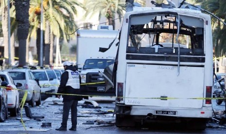 Petugas kepolisian Tunisia memeriksa lokasi dimana sebuah bus hancur diserang aksi bom bunuh diri di Tunis, Tunisia, Rabu (25/11). 