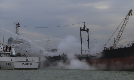 Petugas Kesatuan Penjaga Laut dan Pantai (KPLP) dengan KN Rantos menyemprotkan air ke arah kapal tanker yang terbakar di pelabuhan rakyat, Batu Ampar, Batam, Kepulauan Riau, Rabu (16/11). 