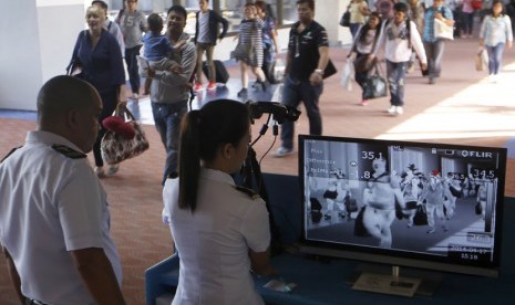   Petugas kesehatan Bandara Ninoy Aquino International Airport di Manila, memeriksa para penumpang pesawat dari kawasan yang diduga terjangkit virus MERS.