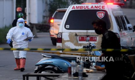 Petugas kesehatan dengan menggunakan baju hazmat melapor di pos masuk saat mengantarkan pasien Covid-19 di Rumah Sakit Darurat Covid-19 Wisma Atlet, Jakarta, Ahad (13/6). 