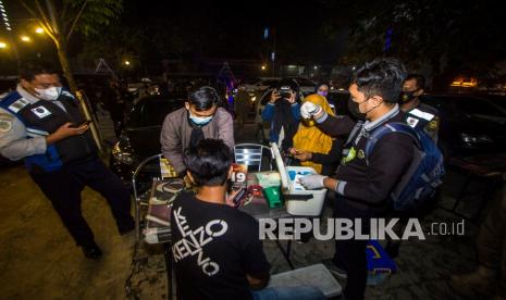 Petugas Kesehatan melakukan pengecekan kesehatan pada warga saat Vaksin on the road di Banjarmasin, Kalimantan Selatan, Jumat (31/12/2021) malam. Di malam pergantian tahun 2021-2022 Dinas Kesehatan Kota Banjarmasin menyelenggarakan vaksin on the road serentak di lima kecamatan Kota Banjarmasin bertujuan untuk meratanya masyarakat yang sudah divaksin hingga kekebalan berkelompok di Banjarmasin meningkat. 