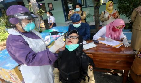 Petugas kesehatan melakukan sweb tes antigen kepada guru di SMPN 3 Kota Kediri, Jawa Timur, Senin (24/1/2022). Pemerintah Kota Kediri melakukan sweb tes antigen secara acak kepada 400 siswa dan guru di sejumlah sekolah tingkat SD hingga SMA guna mendeteksi penyebaran COVID-19 varian Omicron saat pembelajaran tatap muka.