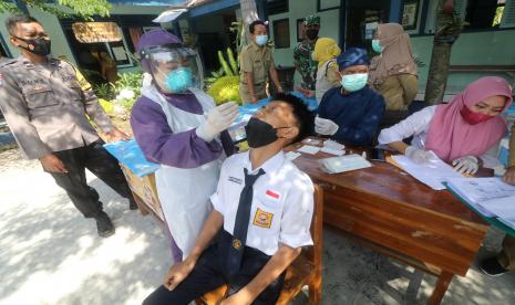 Petugas kesehatan melakukan sweb tes antigen kepada siswa di SMPN 3 Kota Kediri, Jawa Timur, Senin (24/1/2022). Pemerintah Kota Kediri melakukan sweb tes antigen secara acak kepada 400 siswa dan guru di sejumlah sekolah tingkat SD hingga SMA guna mendeteksi penyebaran COVID-19 varian Omicron saat pembelajaran tatap muka. 