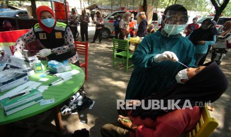 Petugas kesehatan melakukan tes usap antigen kepada pedagang di Obyek Wisata Pantai Alam Indah, Tegal, Jawa Tengah, Sabtu (12/6/2021). Tes usap antigen dan penyuntikan vaksinasi kepada pedagang dan tukang parkir tempat wisata oleh Dinas Kesehatan dan TNI/Polri tersebut guna pengendalian penyebaran COVID-19 di ruang publik menyusul semakin meningkatnya kasus COVID-19 di Kota Tegal. 