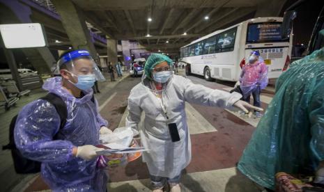 Petugas kesehatan memandu turis China dari Shanghai yang tiba di Bandara Suvarnabhumi, Bangkok, Thailand. Ilustrasi.