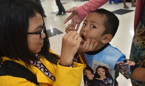 Petugas kesehatan memberikan imunisasi Polio kepada seorang anak di salah satu pusat perbelanjaan, Abepura, Kota Jayapura, Papua, Senin (14/3).