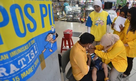 Petugas kesehatan memberikan imunisasi Polio kepada seorang anak di salah satu pusat perbelanjaan, Abepura, Kota Jayapura, Papua, Senin (14/3).