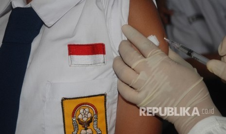 Petugas kesehatan memberikan vaksin Measles Rubella (MR) kepada siswa saat Kampanye Imunisasi Campak dan MR di SMPN 9, Bandung, Jawa Barat, Selasa (1/8). 