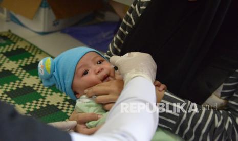 Petugas kesehatan memberikan vaksin polio dan campak kepada anak balita (ilustrasi).