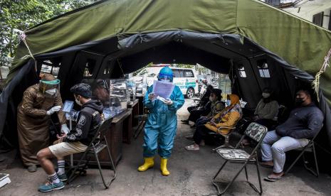 Petugas kesehatan memeriksa kesehatan warga sebelum menjalani uji usap PCR di UPT Puskesmas Tamblong, Kota Bandung.