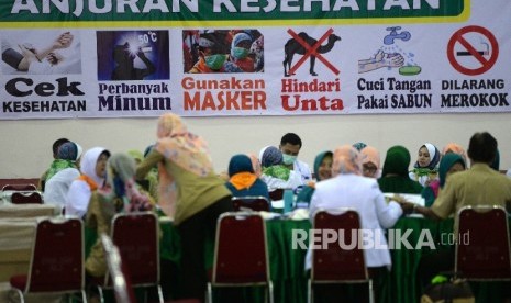  Petugas kesehatan memeriksa riwayat kesehatan jamaah calon haji Kloter 25 di Embarkasi DKI Jakarta, Pondok Gede, Jakarta, Selasa (8/8)