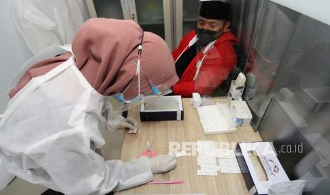 Petugas kesehatan memeriksa sampel lendir hidung saat Rapid Diagnostic Test Antigen (ilustrasi)