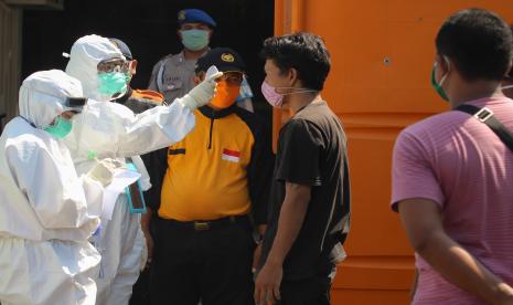 Petugas kesehatan memeriksa suhu tubuh warga di pos pemeriksaan (check point) Rungkut Menanggal Surabaya, Jawa Timur, Sabtu (2/5/2020). Pada hari kelima pelaksanaan PSBB di Surabaya, petugas gabungan di pos pemeriksaan tersebut meminta sejumlah pengendara untuk kembali ke luar Kota Surabaya disebabkan salah satu diantaranya melebihi jumlah 50 persen kapasitas penumpang kendaraan bermotor.