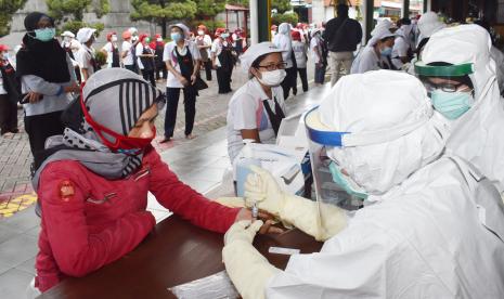 Petugas kesehatan mengambil sampel darah pekerja saat tes diagnostik cepat (rapid test) COVID-19 