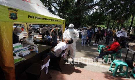 Petugas kesehatan mengambil sampel usap warga saat mengikuti rapid test antigen gratis di kawasan Melawai raya, Jakarta, Kamis (24/12/2020). Polri mengadakan rapid test antigen gratis untuk masyarakat di 10 Pos Pengamanan Operasi Lilin 2020 yang berada di wilayah Jakarta Selatan pada libur Natal 2020 dan Tahun Baru 2021.