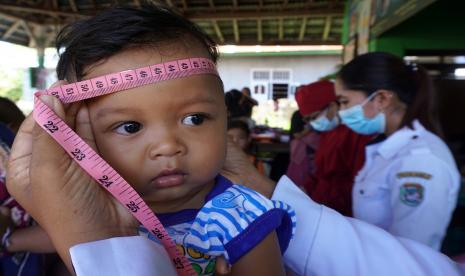 Petugas kesehatan mengukur lingkaran kepala anak (ilustrasi). Mengukur lingkar kepala anak secara rutin dipercaya dapat membantu mendeteksi tumor di kepala.