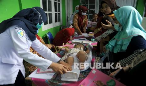 Petugas kesehatan menimbang berat badan bayi di Posyandu Delima 33, Palembang, Sumatra Selatan, Rabu (24/3/2021). Memantau pertambahan berat badan bayi merupakan salah satu cara deteksi dini stunting.