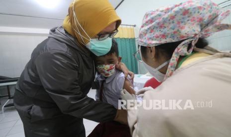 Petugas kesehatan menyuntikan vaksin Measles and Rubella (MR) kepada siswa SDN Burengan 2, Kota Kediri, Jawa Timur, Senin (13/9/2021). Dinas Kesehatan daerah setempat memberikan imunisasi MR lanjutan untuk anak usia sembilan bulan hingga 15 tahun saat hari pertama pembelajaran tatap muka terbatas. 