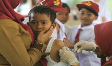 Petugas kesehatan menyuntikkan vaksin campak kepada murid kelas satu saat bulan imunisasi anak sekolah (BIAS) di SDN Sukareja, Balongan, Indramayu, Jawa Barat, Senin (29/8/2022). Anak yang gampang sakit karena tidak menerima imunisasi lengkap akan mengalami gangguan nutrisi karena nafsu makannya terganggu. Mereka berisiko stunting. 