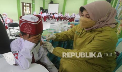 Petugas kesehatan menyuntikkan vaksin Covid-19 kepada anak saat peluncuran vaksinasi Covid-19 untuk anak usia 6-11 tahun   (ilustrasi) 