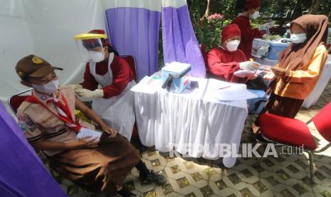 Petugas kesehatan menyuntikkan vaksin COVID-19 kepada pelajar SD di Taman Hutan Kota Joyoboyo, Kota Kediri, Jawa Timur, Jumat (22/10/2021). Pemerintah daerah setempat berupaya mempercepat vaksinasi COVID-19 melalui vaksinasi massal kepada pelajar SD usia 12 tahun ke atas seiring telah dimulainya Pembelajaran Tatap Muka Terbatas (PTMT) di sejumlah sekolah. 