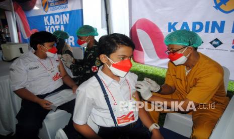 Petugas kesehatan menyuntikkan vaksin COVID-19 kepada pelajar SMP saat vaksinasi massal di Kebun Raya Bogor, Jawa Barat, Sabtu (28/8/2021). Pemerintah menggencarkan program vaksinasi bagi pelajar untuk mendukung persiapan pelaksanaan Pembelajaran Tatap Muka (PTM) terbatas di daerah sebagai upaya melindungi insan pendidikan dan keluarganya dari potensi penyebaran COVID-19. 