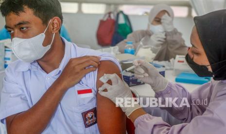 Petugas kesehatan menyuntikkan vaksin COVID-19 kepada seorang pelajar saat vaksinasi massal di Pakansari, Cibinong, Kabupaten Bogor, Jawa Barat, Kamis (9/9/2021). Pemerintah Provinsi Jawa Barat saat ini tengah mengejar target 424 ribu suntikan vaksin per harinya, sehingga diharapkan pada akhir tahun kekebalan kelompok bisa terbentuk. 