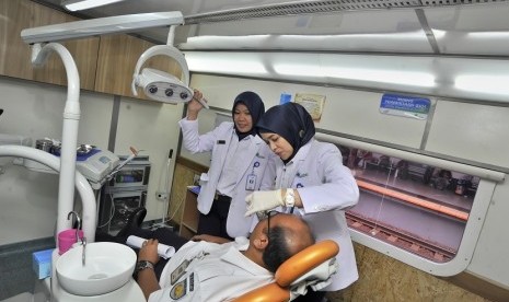 Petugas kesehatan PT KAI menunjukkan layanan pemeriksaan gigi saat peluncuran kereta api kesehatan (Rail Clinic) pertama Indonesia di Stasiun KA Pasar Senen, Jakarta, Sabtu (12/12).