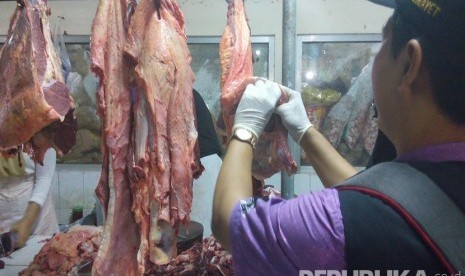 Petugas Kesmavet Dinas Peternakan dan Perikanan Kabupaten Semarang memeriksa daging sapi yang dijual salah seorang pedagang di Pasar Babadan, Kabupaten Semarang, Jawa Tengah, Jumat (3/6) dini hari. (Republika/Bowo Pribadi)