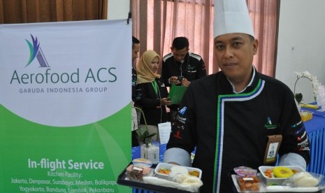 Petugas koki Garuda Indonesia memperlihatkan menu 