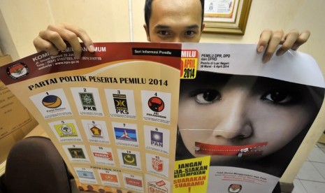   Petugas Komisi Pemilihan Umum (KPU) menunjukkan poster sosialisasi penyelenggaraan Pemilu 2014 di Jakarta, Jumat (7/2).   (Antara/Yudhi Mahatma)