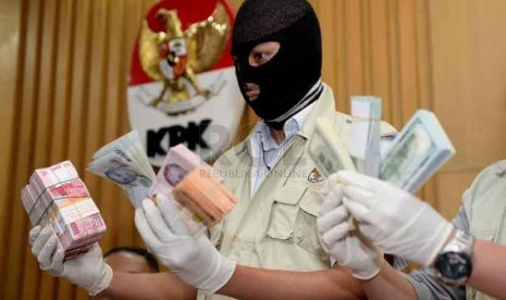 Petugas KPK menunjukan barang bukti uang dalam pecahan Rupiah dan Dolar Singapura hasil operasi tangkap tangan Gubernur Riau Annas Maamun di Gedung KPK, Jakarta, Jumat (26/9).(Republika/ Wihdan)