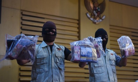 Petugas KPK menunjukkan barang bukti uang saat konferensi pers tentang Operasi Tangkap Tangan KPK di Gedung KPK, Jakarta, Selasa (12/4).