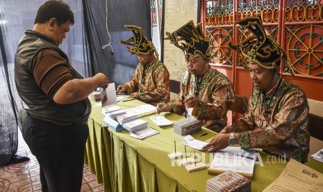 Petugas KPPS membantu warga yang akan memberikan hak suaranya di TPS 005 Pemilu 2019 di Kelurahan Cibadak, Kecamatan Astanaanyar, Kota Bandung, Rabu (17/4).