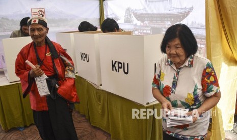 Petugas KPPS membantu warga 