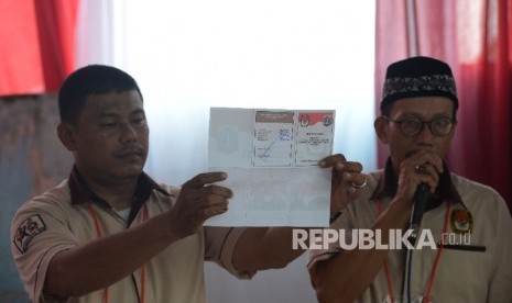 Petugas KPPS menunjukkan surat suara.