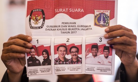 Petugas KPPS menunjukkan surat suara saat menghitung jumlah suara pada Pemilihan Gubernur DKI Jakarta di TPS 28 Cilandak Barat, Jakarta, Rabu (15/2).