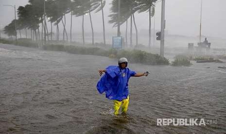 Petugas lalulintas menutup jalanan yang dilanda banjir akibat  terpaan Topan Mangkhut di Manila, Sabtu (15/9).