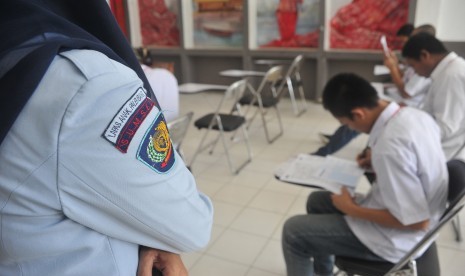 Petugas Lapas mengawasi anak didik Lapas yang mengerjakan soal Ujian Nasional