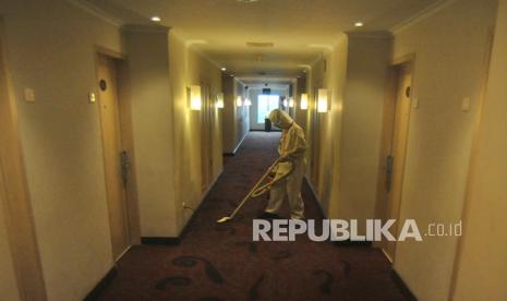 Petugas layanan kamar menggunakan pakaian APD lengkap saat membersihkan koridor hotel. Saat ini pelancong mempertimbangkan standar kesehatan saat akan berwisata. Ilustrasi.