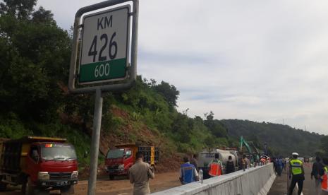 Petugas masih membersihkan material longsor yang menutup badan jalan tol di KM 426+600 B, di ruas antara GT Banyumanik- GT Ungaran, Ahad (31/5). Akibatnya, arus lalu lintas di ruas jalan tol ini sementara dialihkan ke jalur utama.