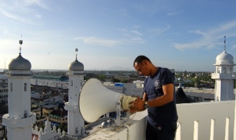 Petugas masjid mengecek peralatan pengeras suara yang ditempatkan di puncak menara Masjid Raya Baiturrahman Banda Aceh, Rabu (25/6) sore. Sirine yang sudah berusia puluhan tahun itu terkoneksi dengan pengeras suara hanya dibunyikan sekali dalam setahun pad