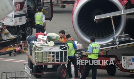 Petugas masukan barang milik penumpang ke bagasi pesawat di Bandara Internasional Soekarno,-Hatta, Tanggerang,Banten, Kamis (7/2). Kementerian Perhubungan (Kemenhub) tengah merumuskan aturan mengenai penetapan tarif bagasi untuk maskapai Low Cost Carrier (LCC). Upaya ini dilakukan sebagai bentuk tindak lanjut perlindungan para penumpang dan bisnis maskapai.